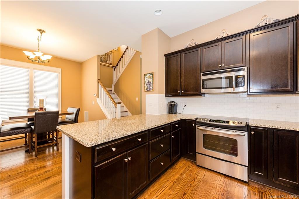 225 Coneflower Place, Unit 1405 Fort Mill, SC 29708 - Photo 11 of 22 a kitchen with kitchen island granite countertop wooden cabinets granite counter tops and a stove