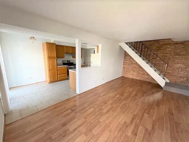 a view of a living room hardwood floor and a kitchen
