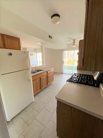a kitchen with a stove a refrigerator and a sink
