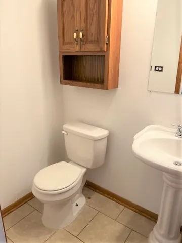 a bathroom with a toilet a sink and a mirror
