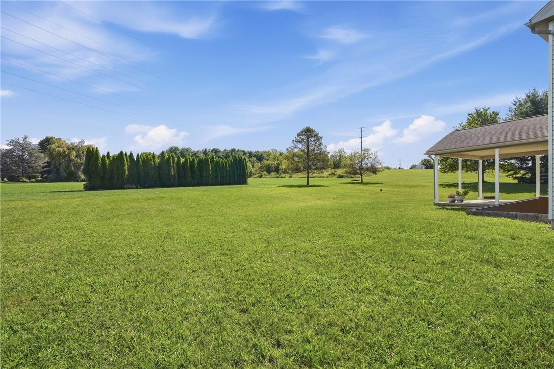 590 Fehr Road Nazareth, PA 18064 - Photo 68 of 79 A spacious green lawn stretches out from the covered porch under clear blue skies.