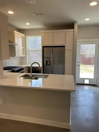 a kitchen with granite countertop a sink a stove and cabinets