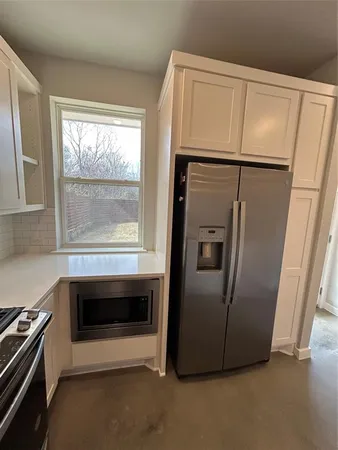 a metallic refrigerator freezer sitting in a kitchen
