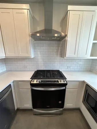 a kitchen with granite countertop white cabinets and white appliances