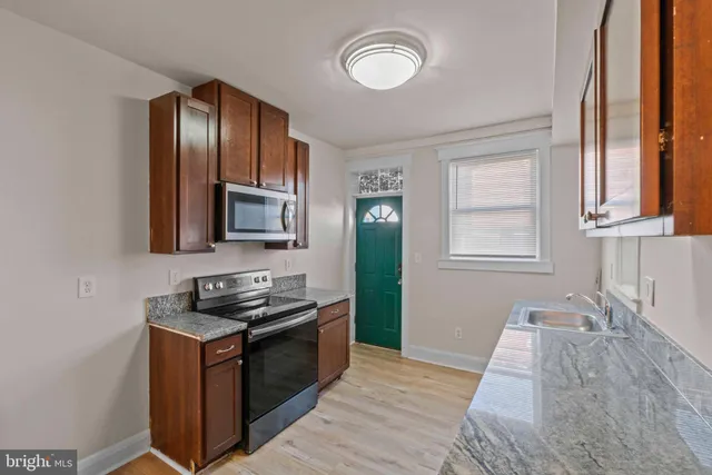 a kitchen with granite countertop stainless steel appliances and wooden cabinets