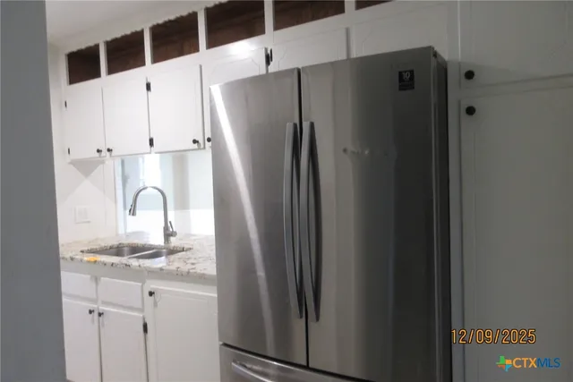 a close view of a refrigerator in kitchen and a sink