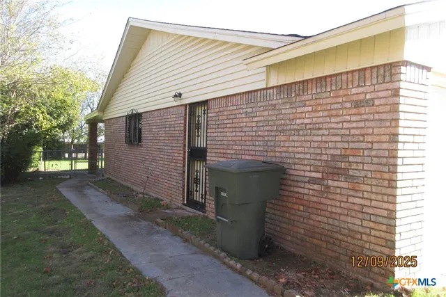 a view of a house with backyard and trees