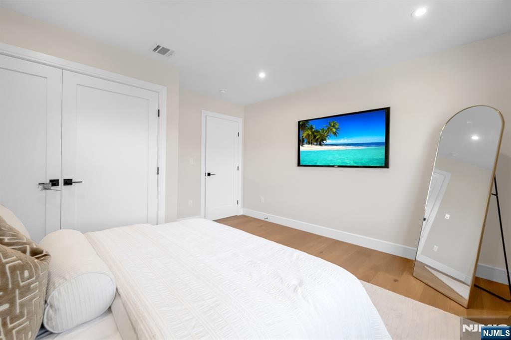 92 West Main Street Ramsey, NJ 07446 - Photo 28 of 47 a bedroom with a bed and a flat screen tv