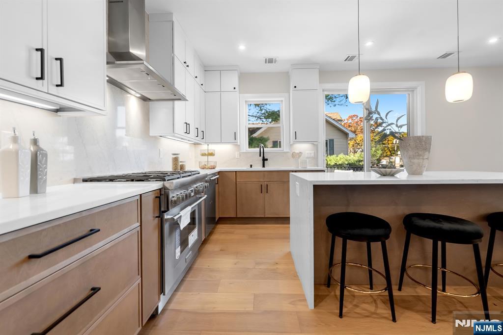 92 West Main Street Ramsey, NJ 07446 - Photo 3 of 47 a kitchen with stainless steel appliances granite countertop a sink a stove and a wooden floors