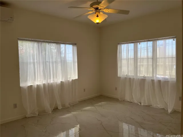 an empty room with windows and fan