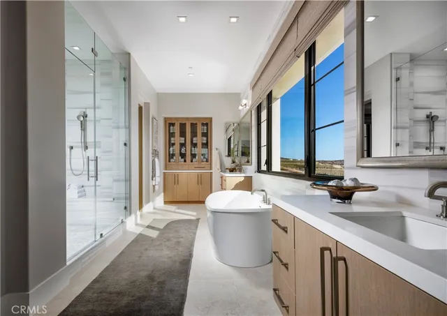 a bathroom with a double vanity sink a mirror and a bathtub