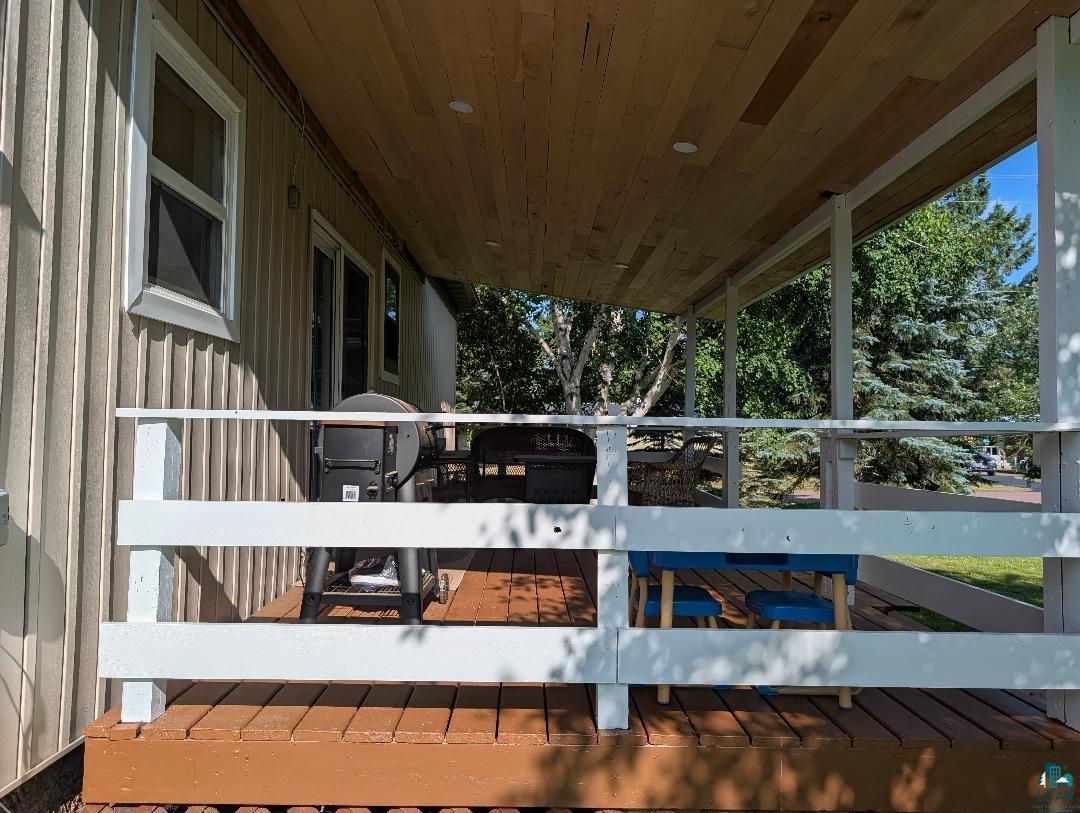 701 Drake Street Mellen, WI 54546 - Photo 6 of 27 Covered outdoor deck with white railing, wood-finish flooring, and a natural wood plank ceiling