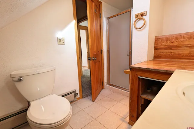 a bathroom with a toilet a sink and shower