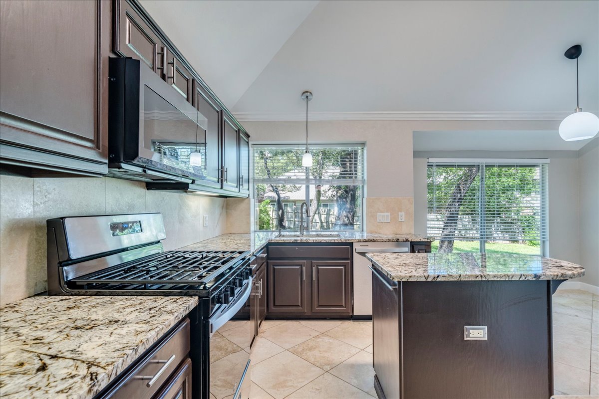 6530 Needham Lane Austin, TX 78739 - Photo 11 of 29 Granite counters and stainless steel appliances adorn this functional, sun-filled kitchen.