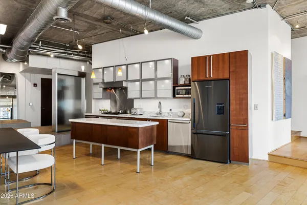 a kitchen with stainless steel appliances granite countertop a refrigerator a stove a sink and a refrigerator