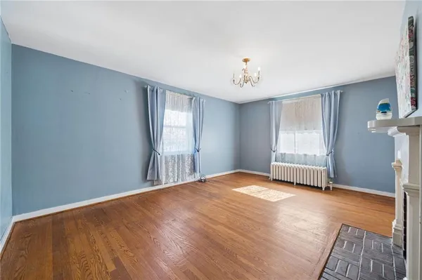 a view of empty room with wooden floor and fireplace