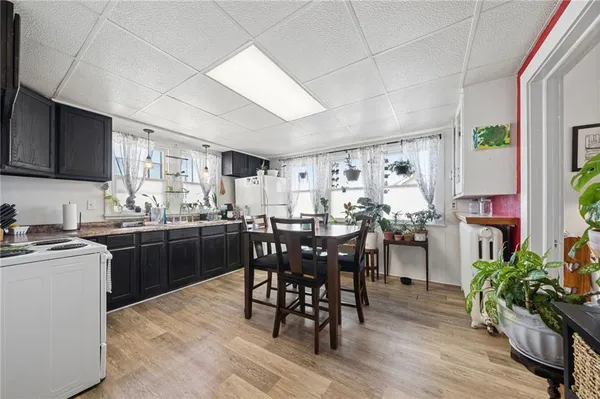 a kitchen with stainless steel appliances a white table and chairs in it