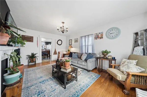 a view of a hallway with wooden floor and a potted plant