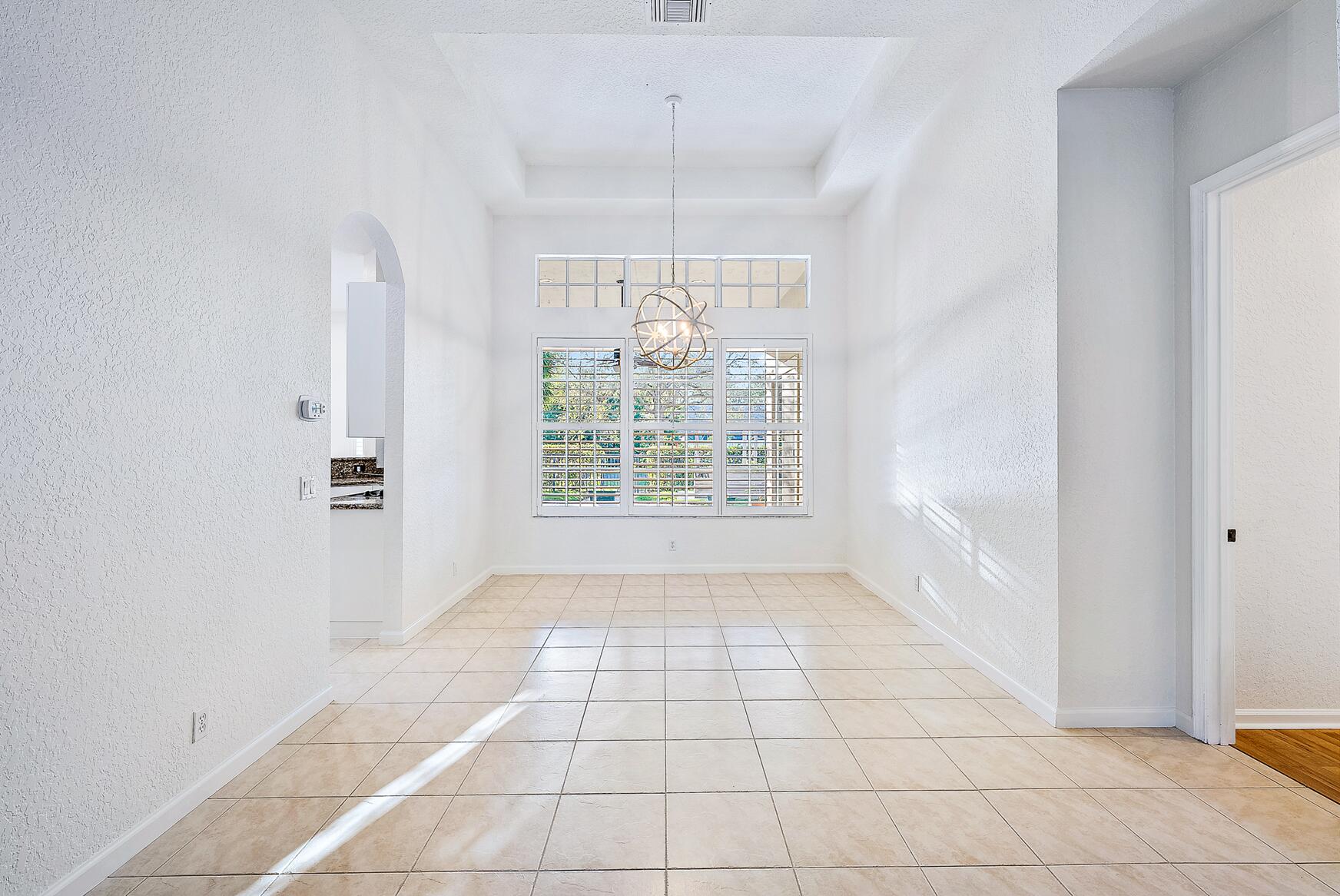 116 Via Rosina Jupiter, FL 33458 - Photo 14 of 33 an empty room with windows and chandelier