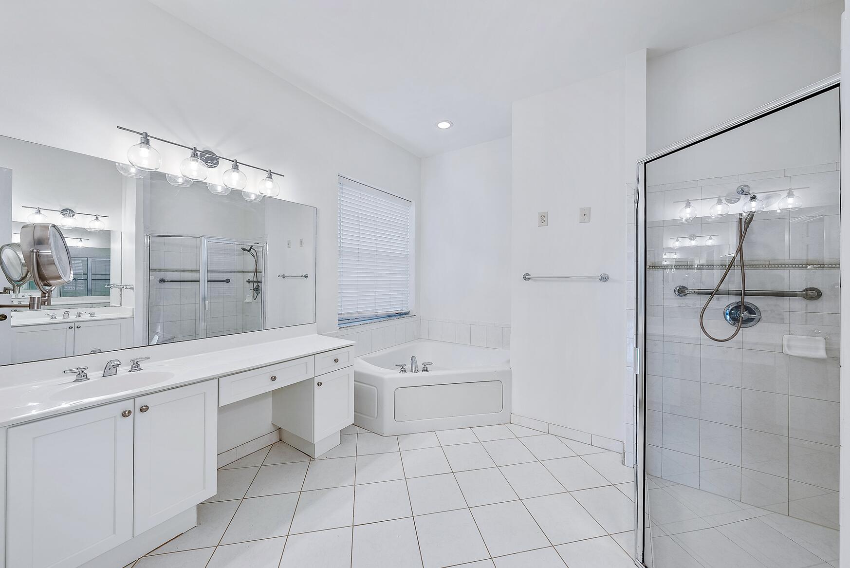 116 Via Rosina Jupiter, FL 33458 - Photo 17 of 33 a spacious bathroom with a shower sink and mirror