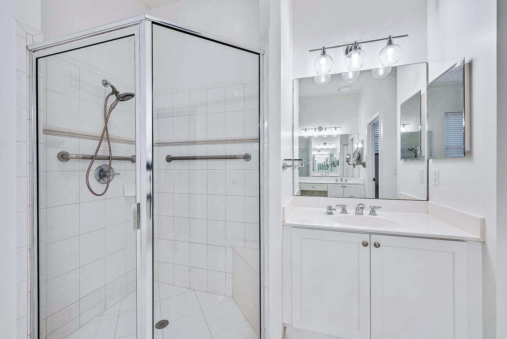 116 Via Rosina Jupiter, FL 33458 - Photo 18 of 33 a bathroom with a shower sink and mirror