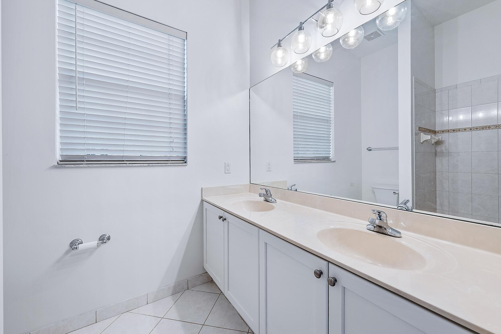 116 Via Rosina Jupiter, FL 33458 - Photo 22 of 33 a bathroom with a sink and a mirror