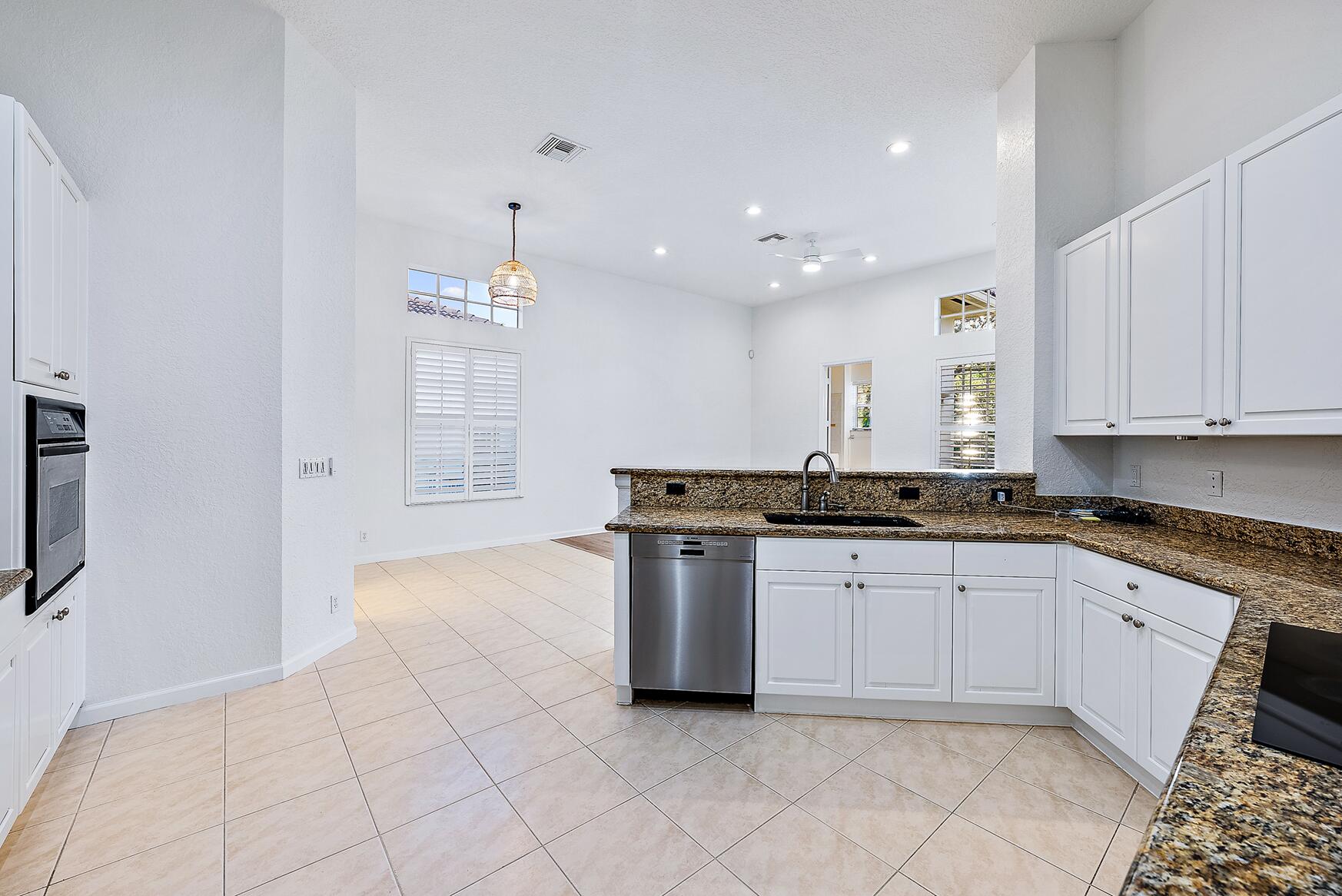 116 Via Rosina Jupiter, FL 33458 - Photo 10 of 33 a kitchen with stainless steel appliances granite countertop a stove a sink and a refrigerator