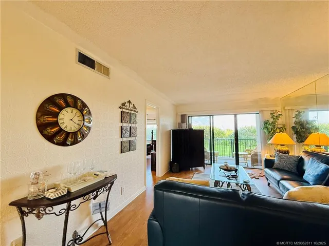 a living room with furniture a flat screen tv and a large window