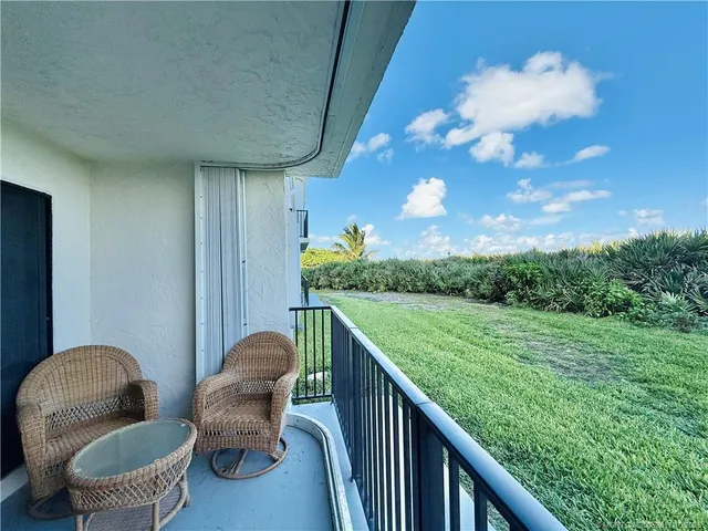 a view of a green field of grass and trees