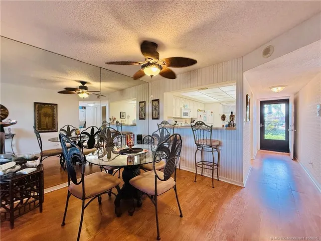 a view of a dining room with furniture and chandelier fan