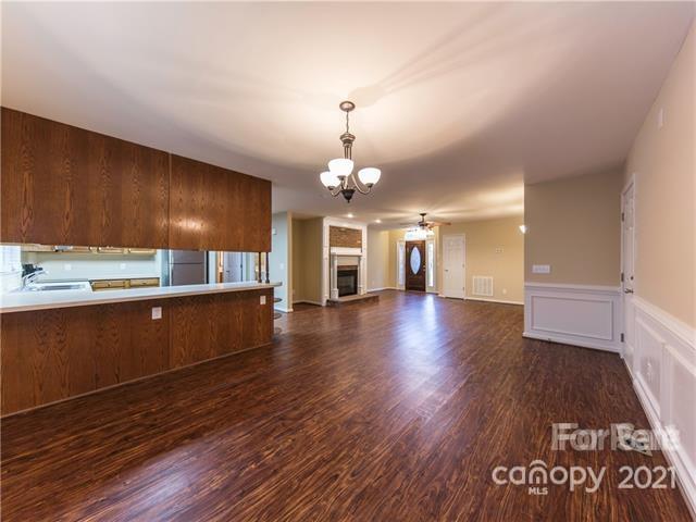 1347 Mistletoe Ridge Place Northwest Concord, NC 28027 - Photo 11 of 34 a view of a kitchen and an empty room with wooden floor