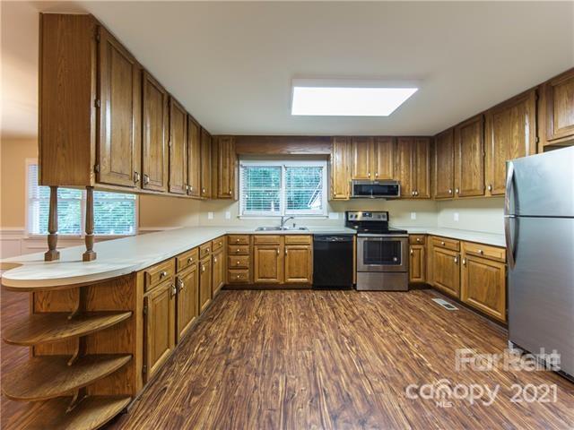 1347 Mistletoe Ridge Place Northwest Concord, NC 28027 - Photo 12 of 34 a kitchen with granite countertop wooden floors stainless steel appliances a sink and a window