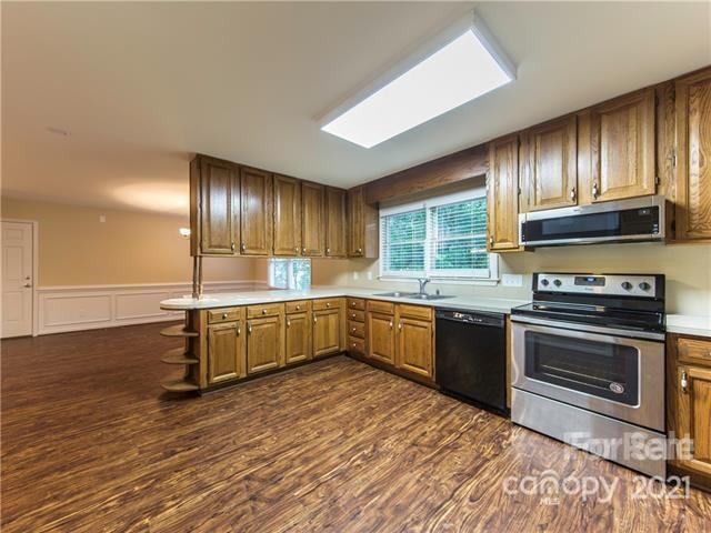 1347 Mistletoe Ridge Place Northwest Concord, NC 28027 - Photo 13 of 34 a kitchen with stainless steel appliances kitchen island granite countertop a stove a sink and a refrigerator