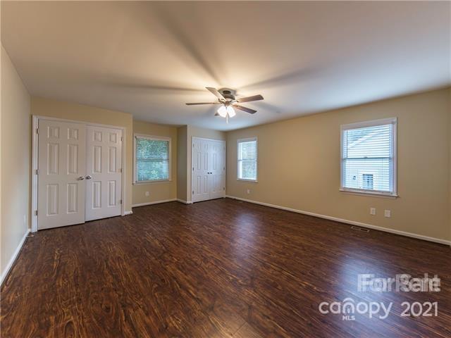 1347 Mistletoe Ridge Place Northwest Concord, NC 28027 - Photo 17 of 34 an empty room with wooden floor chandelier fan and windows