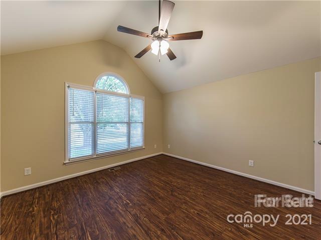 1347 Mistletoe Ridge Place Northwest Concord, NC 28027 - Photo 23 of 34 an empty room with wooden floor chandelier fan and windows