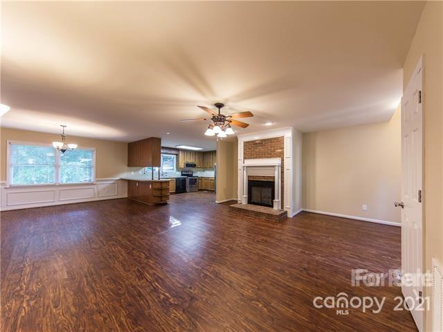 1347 Mistletoe Ridge Place Northwest Concord, NC 28027 - Photo 6 of 34 an empty room with wooden floor fireplace and windows