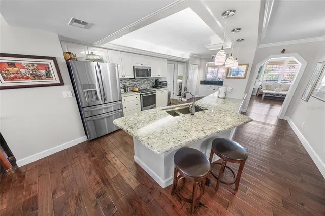 a view of a dining room with furniture a rug and wooden floor