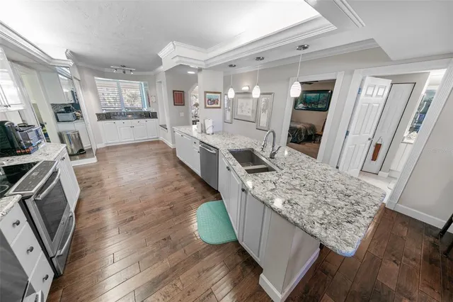 a living room with stainless steel appliances granite countertop furniture wooden floor and a view of kitchen