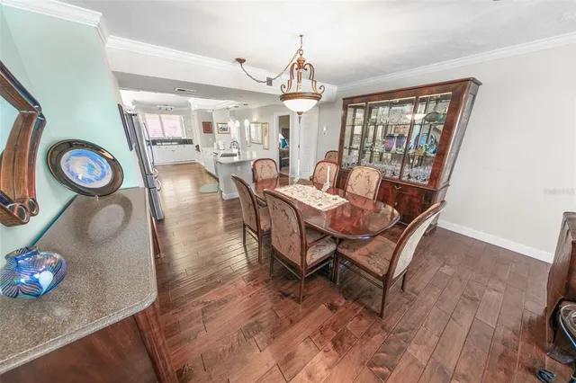 a dining room with wooden floor and large windows