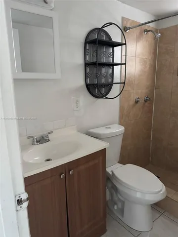 a bathroom with a sink a mirror a toilet and a shower