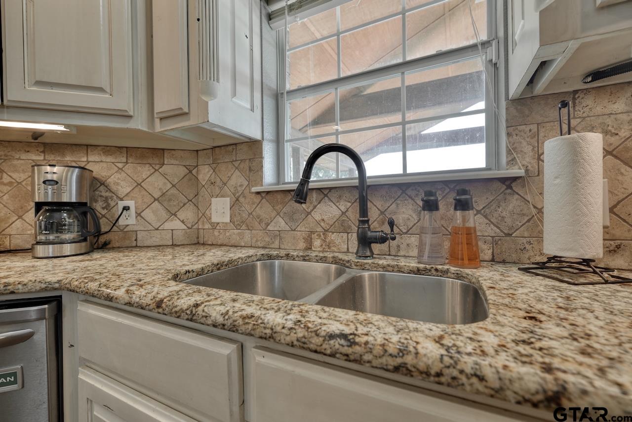 a kitchen with granite countertop a sink and a window
