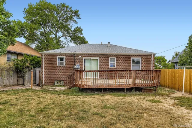 a view of a house with a wooden deck and a yard