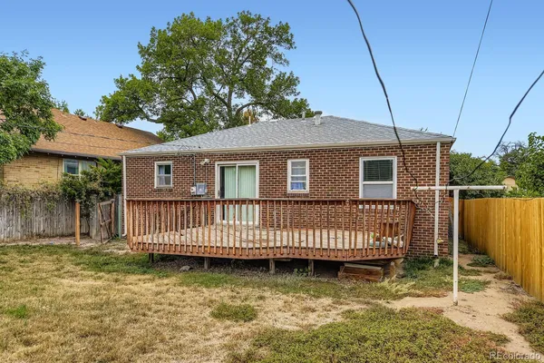 a view of a house with wooden deck and a yard