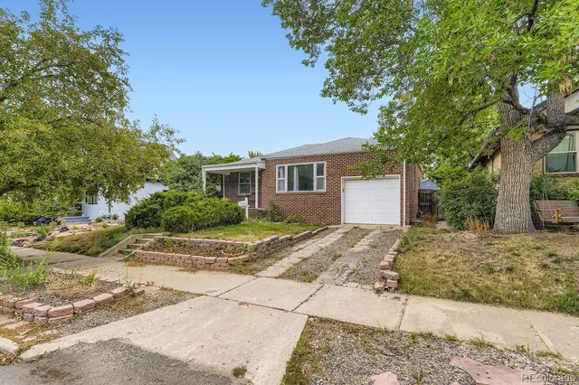 a view of a house with a yard and large tree