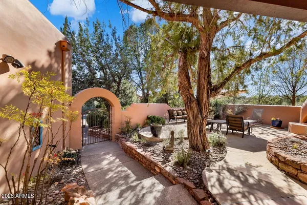 a backyard of a house with table and chairs under an umbrella