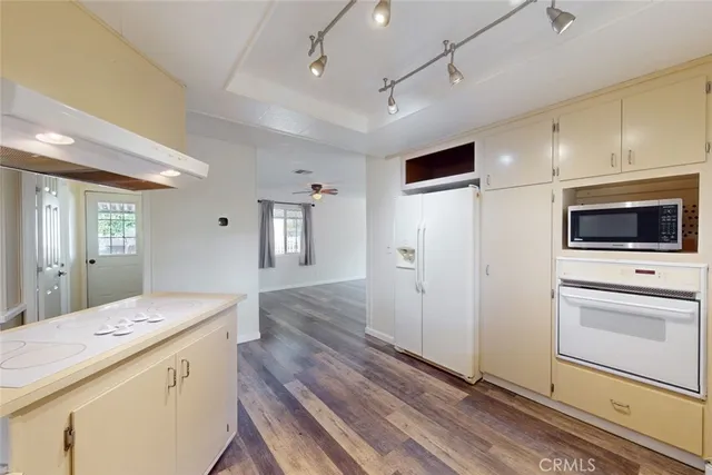 a kitchen with a refrigerator a stove cabinets and wooden floor