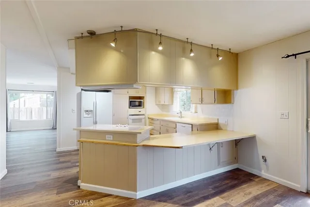 a view of a kitchen with wooden floor and a window