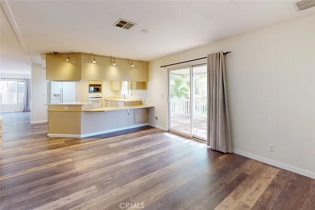 a view of kitchen and hall with wooden floor
