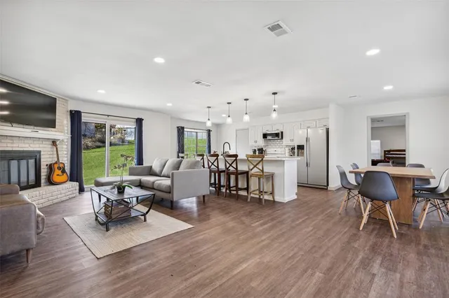 a living room with furniture dining table wooden floor and a fireplace