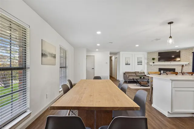 a large kitchen with sink a refrigerator and chairs